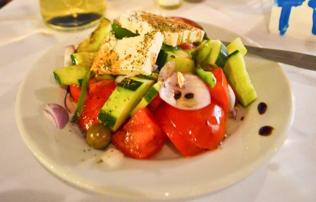 Fresh greek salad in a white bowl