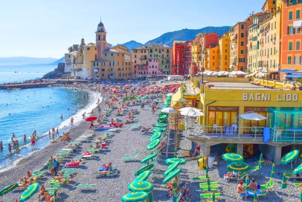 Colorful seaside buildings line a pebbled beach in Camogli Italy on the Italian Riviera