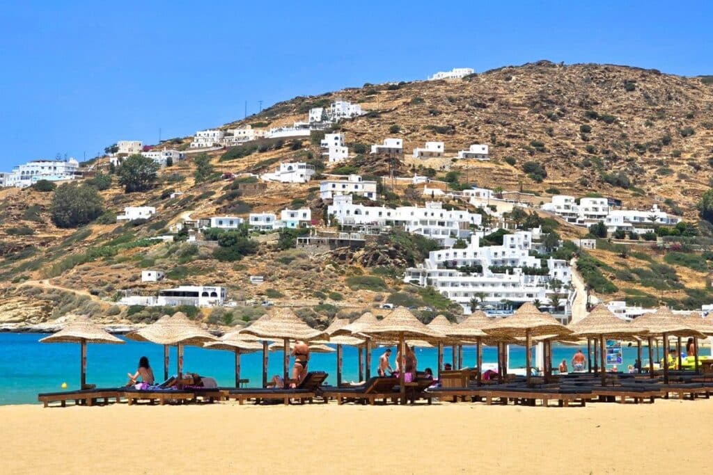 The golden sands of Mylopotas lined with lounge chairs